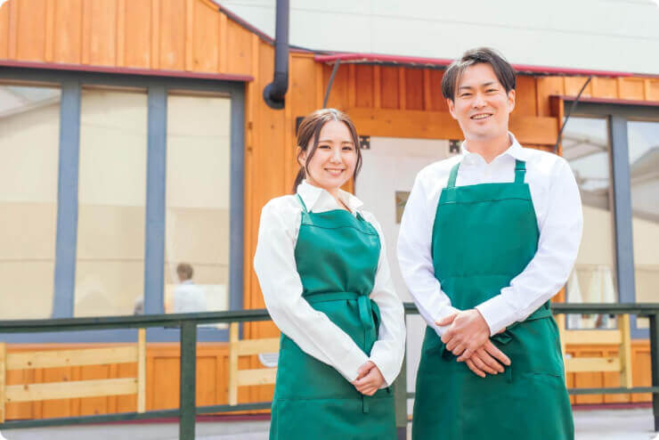 お店の前で2人のスタッフが立っている写真